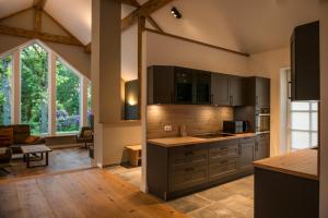 a kitchen with wooden cabinets and a living room at Landhaus Bockelmann, Natur trifft Komfort in Bispingen
