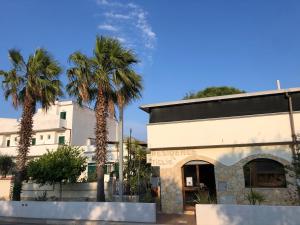 a building with palm trees in front of it at Tiglio Vieste in Vieste