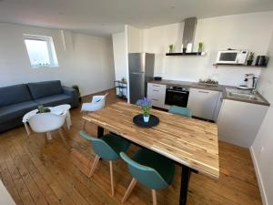a kitchen and living room with a wooden table and chairs at George V - Enjoy the view of the sea channel in Les Sables-dʼOlonne +4 photos