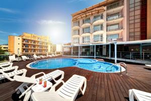 una piscina con tumbonas y un hotel en хотел Свети Николай Приморско en Primorsko