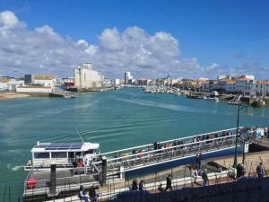 a pier with a boat in the water at George V - Enjoy the view of the sea channel in Les Sables-dʼOlonne