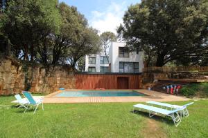 a house with a swimming pool and two lawn chairs at Apartamento 2 dormitorios con piscina y jardín in Somo