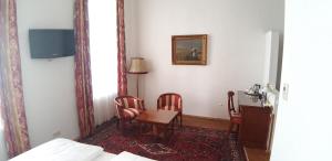 um quarto com uma mesa e cadeiras e um espelho em Hotel Domizil em Viena