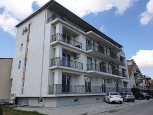 ein weißes Gebäude mit davor geparkten Autos in der Unterkunft Delux Studio Mamaia Nord in Năvodari