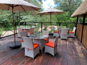 a deck with tables and chairs and an umbrella at Juda Haus Lodge in Katima Mulilo