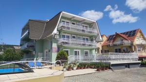 a large house with a swimming pool in front of it at Green Guesthouse Balatonfüred in Balatonfüred