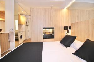 a bedroom with a black and white bed and wooden walls at ESTUDIO PORT EXPERIENCE in Tarragona