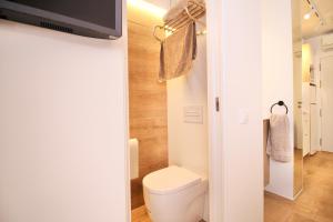 a small bathroom with a toilet and a tv at ESTUDIO PORT EXPERIENCE in Tarragona +10 photos