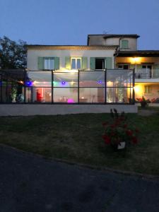 a large house with glass windows in the yard at logement avec piscine couverte chauffée d'avril à octobre et spa privatifs, vue in Estivareilles