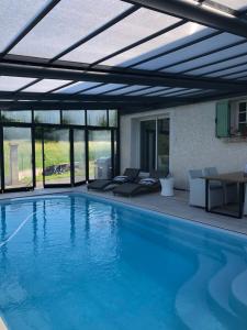 a large swimming pool with a retractable roof at logement avec piscine couverte chauffée d'avril à octobre et spa privatifs, vue in Estivareilles