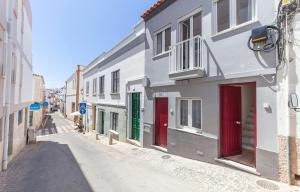 ラゴスにあるOlive Tree Street 2 Bed Flatの赤と緑の扉が付いた白い建物の路地