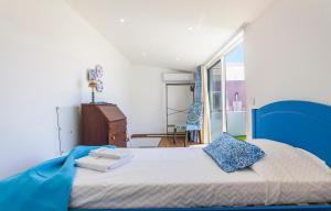 een slaapkamer met een blauw en wit bed en een raam bij B48 - Olive Tree Street 2 Bed Apartement in Lagos