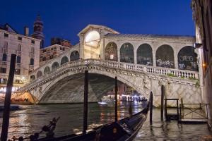 a bridge over a river with a gondola at ItaliaHaus - Ca' Olivo loft with canal view in Rialto Venice in Venice