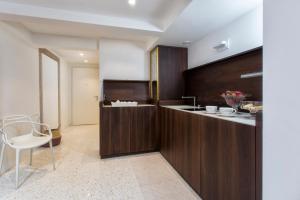 a kitchen with wooden cabinets and a white chair at ItaliaHaus - Ca' Olivo loft with canal view in Rialto Venice in Venice