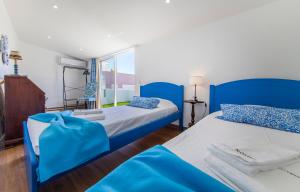 twee bedden in een kamer met blauw en wit bij B48 - Olive Tree Street 2 Bed Flat in Lagos