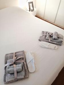 a white bed with towels and a box on it at Chic In The City in Bolzano