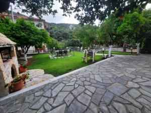 a stone walkway with a park in the background at Nerajoula House in Parga