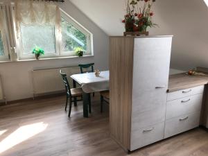 ザルツヴェーデルにあるFerienwohnung Salzwedelのキッチン(テーブル、白いキャビネット付)