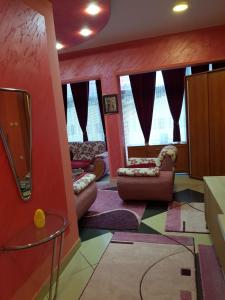 ein Wohnzimmer mit roten Wänden und farbenfrohem Teppich in der Unterkunft Apartman Lazić No-2 in Gračanica