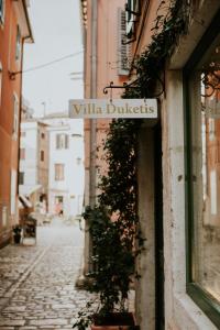 a sign on the side of a building with a street at Rooms Villa Duketis in Rovinj