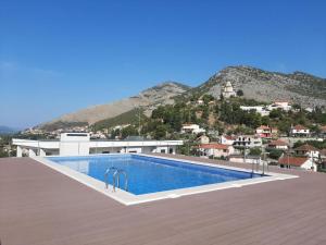 a swimming pool on top of a building with a mountain at APARTMAN AURORA in Trebinje