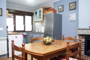 a kitchen with a wooden table with a bowl of fruit on it at Casa CORCEDU in Inguanzo