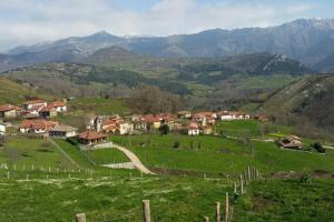 a village on a hill with mountains in the background at Casa CORCEDU in Inguanzo