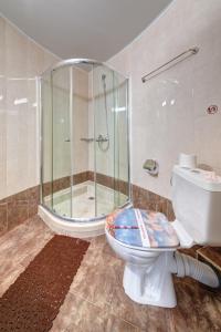 a bathroom with a toilet and a glass shower at хотел Свети Николай Приморско in Primorsko