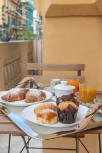 una mesa con dos platos de bollería y zumo de naranja en Palazzo Nanà Suites & Apartments, en Nápoles