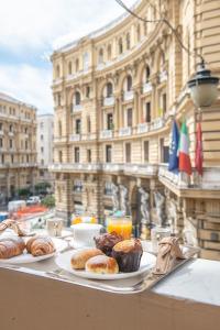 una mesa con dos platos de bollería y zumo de naranja en Palazzo Nanà Suites & Apartments, en Nápoles