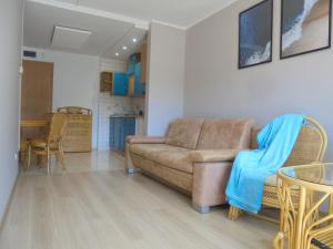 a living room with a couch and a table at Apartament dwupokojowy 150 m do morza in Jarosławiec