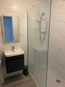 ein Badezimmer mit Dusche und Waschbecken in der Unterkunft Causeway Coast Apartments Cora Marine in Ballycastle + 26 Fotos