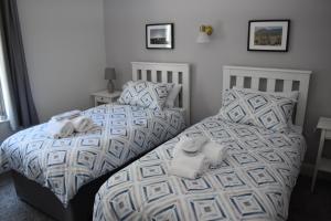 twee bedden in een slaapkamer met handdoeken erop bij Causeway Coast Apartments Cora Marine in Ballycastle