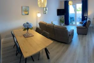 ein Wohnzimmer mit Tisch und Couch in der Unterkunft Causeway Coast Apartments Cora Marine in Ballycastle