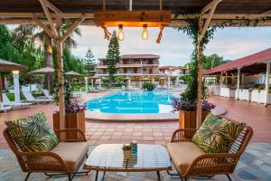 a patio with a pool and chairs and a table at Almira Hotel in Troulos