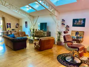 uma sala de estar com mobiliário de couro e uma televisão em Superbe LOFT centre-ville - Sauna - parking privé -Clim- 1 à 10personnes em Brive-la-Gaillarde