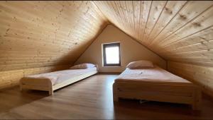 two beds in a room with wooden ceilings at Apartamenty Pod Skałą in Hoczew