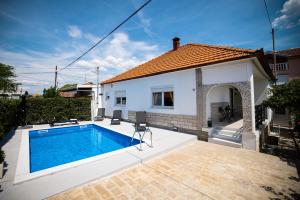a swimming pool in front of a house at Villa Nila Zadar in Zadar