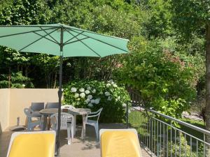 a patio with a table and chairs and an umbrella at Casa de Casarelhos - Andar da Moradia com terraço - Vistas rio - "Gerês" in Geres