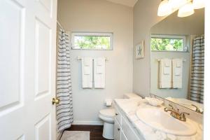 a bathroom with a sink and a toilet and a mirror at ⋘ Hidden Retreat 12min to UF or Downtown Gainesville and 30min to the Springs ⋙ in Gainesville +23 photos