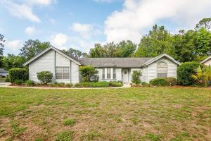 a white house with a large yard at ⋘ Hidden Retreat 12min to UF or Downtown Gainesville and 30min to the Springs ⋙ in Gainesville