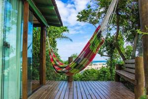 a hammock on the deck of a house at Casinha RDS in Guarda do Embaú