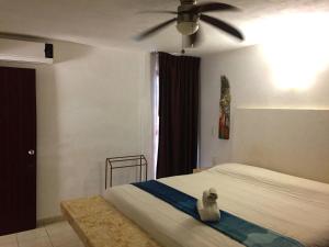 Schlafzimmer mit einem Bett und einem Deckenventilator in der Unterkunft Villa Costa Chica Comodisimo piscina gigante jardines in Acapulco