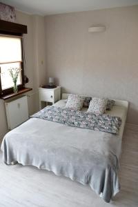 1 dormitorio con 1 cama grande con almohadas y ventana en Wygodna kawalerka., en Kalisz
