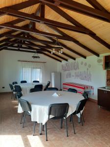 ポロヴラジにあるPensiunea Ana-Mariaのテーブルと椅子が備わる広い客室です。
