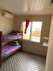 a small room with two bunk beds and a window at Hostel da Paz in Maceió