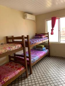 um quarto com 3 beliches e uma janela em Hostel da Paz em Maceió