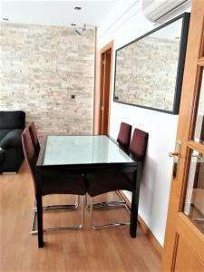 a glass table and chairs in a room at APARTAMENTO HUESCA in Huesca