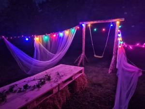 Tienda con luces y mesa de picnic en la oscuridad en Siedlisko Józefka, en Zaróbka