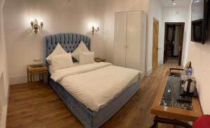 um quarto com uma cama com uma cabeceira azul em Nabat Palace Arbat em Moscou